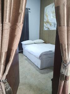a bedroom with a bed with curtains in it at River cliff guest house in Gunungsriti