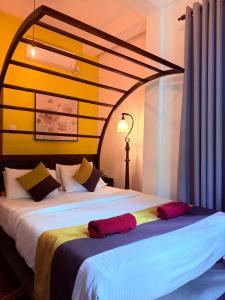 a bedroom with a large bed with red pillows at White House Ella in Ella