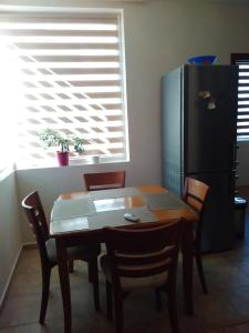 a kitchen with a table and chairs and a refrigerator at Geri Apartment in Burgas