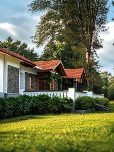 a house with a fence in front of a yard at Nine Pines in Pīrmed