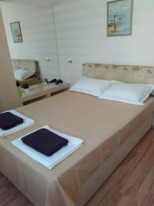 a bedroom with a large bed with two towels on it at Geri Apartment in Burgas City