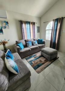 a living room with two couches and a couch at Deluxe Estate in Portmore