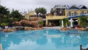 a large swimming pool in front of a resort at Deluxe Estate in Portmore
