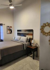 a bedroom with a bed and a mirror and a table at Deluxe Estate in Portmore