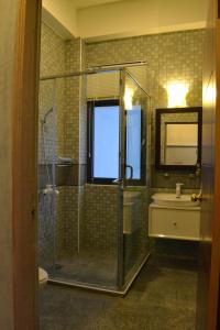 uma casa de banho com um chuveiro e um lavatório. em David SamStrong Villa 大尾山姆維拉 em Chenggong
