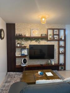 a living room with a flat screen tv on a brick wall at The Lotus Suite2 Iloilo in Iloilo City