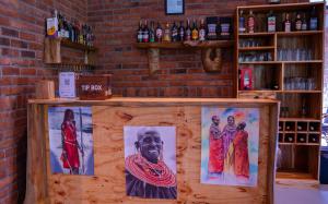 a bar with pictures of people on it at Maksoru Spring Lodge in Arusha