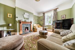 a living room with a couch and a fireplace at High House in Norwich