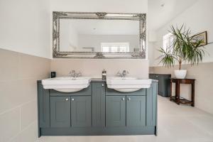 a bathroom with two sinks and a mirror at High House in Norwich +52 photos