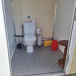 a small bathroom with a toilet and a table at Les Roches Blanches Emplacements camping-car, tente, caravane in Guenroc +7 photos