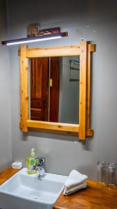 a bathroom sink with a wooden mirror above it at Maksoru Spring Lodge in Arusha +33 photos