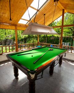 a green pool table in a pavilion with a ceiling at Purnima Little Italy in Manāli