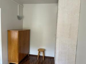 a wooden cabinet and a stool in a room with a wall at Kuremaa Lake in Kuremaa