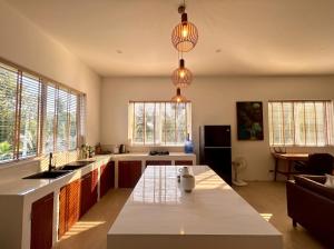 a kitchen with two pendant lights and a kitchen island at Villa Leo in Ban Madua Wan +14 photos