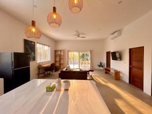 a kitchen and living room with a large white table at Villa Leo in Ban Madua Wan