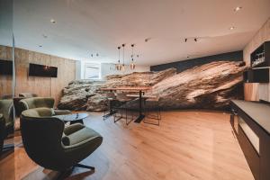 a dining room with a large rock wall at Historic Residence Barbara in Colle Isarco