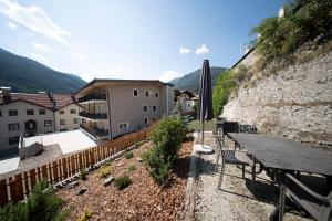 a patio with a table and an umbrella and a building at Historic Residence Barbara in Colle Isarco