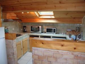 a kitchen with a stove and a microwave at Appartement T2 "Altaïr" de l'observatoire in Bauduen