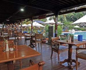 a restaurant with tables and chairs and a pool at Private 2BR Apartment at The Jayakarta Residence Bali in Denpasar