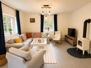 a living room with a couch and a tv at Wellness Chalet Luby in Luby