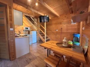 a kitchen with a wooden cabin with a wooden table at CYKADY domki letniskowe Okuninka in Okuninka