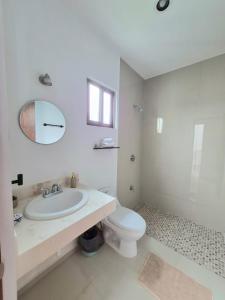 a white bathroom with a sink and a toilet at Casa Terracota Micro Hotel Consulado in Mérida