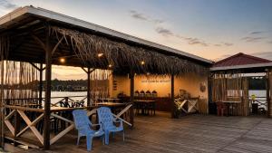 a restaurant with chairs and tables on a deck at Coco Seaweed Resort in Semporna