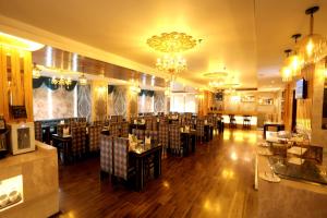 a restaurant with tables and chairs in a room at Park Ocean in Jaipur