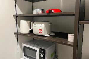 a microwave and a toaster sitting on a shelf at 奄美ラッキー海の家 in Yoan