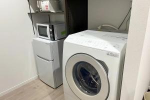 a washing machine with a microwave on top of it at 奄美ラッキー海の家 in Yoan +1 photo