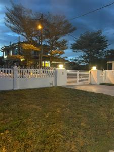 a white fence in front of a house at Haus176 in Bentong