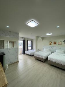 a large room with two beds and a television at ปากช่องอพาร์ทเม้นท์ in Pak Chong +15 photos