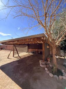 a wooden pavilion with a tree in front of it at Casa de Adobe Doña Tinogasta in Tinogasta