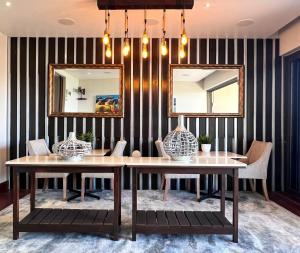 a dining room with two tables and two mirrors at One O Eight Boutique Hotel in Benoni