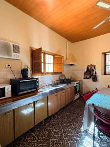 a kitchen with a sink and a microwave at Casa de Adobe Doña Tinogasta in Tinogasta