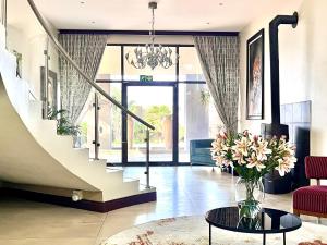 a living room with a vase of flowers on a table at One O Eight Boutique Hotel in Benoni