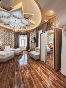 a living room with a gold ceiling and wooden floors at As-Mira Hotel in Samarkand