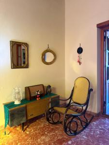 a room with a chair and a table and a mirror at Casa de Adobe Doña Tinogasta in Tinogasta