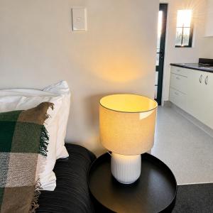 a lamp sitting on a table next to a bed at Kerry Lane Motel in Hawera