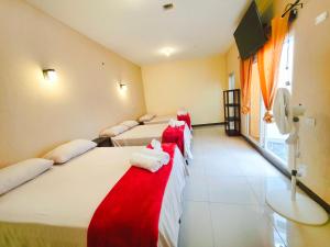 a row of four beds in a room at Guadalupe House Esquipulas in Esquipulas