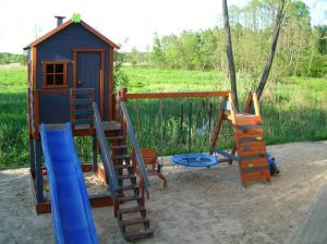 a playground with a play house and a slide at CYKADY domki letniskowe Okuninka in Okuninka
