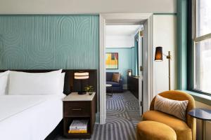 a hotel room with a bed and a chair at The Algonquin Hotel Times Square, Autograph Collection in New York