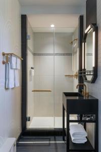 a bathroom with a shower with a sink and a mirror at The Algonquin Hotel Times Square, Autograph Collection in New York +50 photos