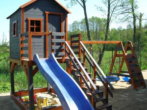a playground with a slide and a play house at CYKADY domki letniskowe Okuninka in Okuninka