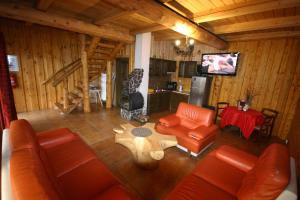 vistas panorámicas a una sala de estar con muebles de color naranja en Zbojnícka drevenica 2, en Liptovský Mikuláš – Demänová