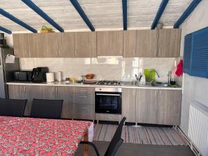 a kitchen with a stove and a table with chairs at CAZARE JASMINA in Corbu