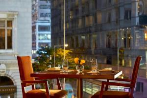 a table with chairs and wine glasses on a window at Sheraton Hong Kong Hotel & Towers in Hong Kong
