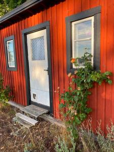 a red cabin with a door and a window at Havsutsikt in Ronneby