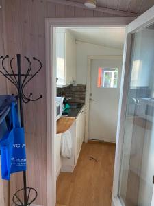 a kitchen with white cabinets and a door leading into a room at Havsutsikt in Ronneby