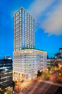 a tall white building in a city at night at The St. Regis Osaka in Osaka